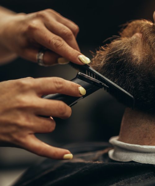 young-bearded-man-getting-beard-haircut-by-hairdresser-2.jpg